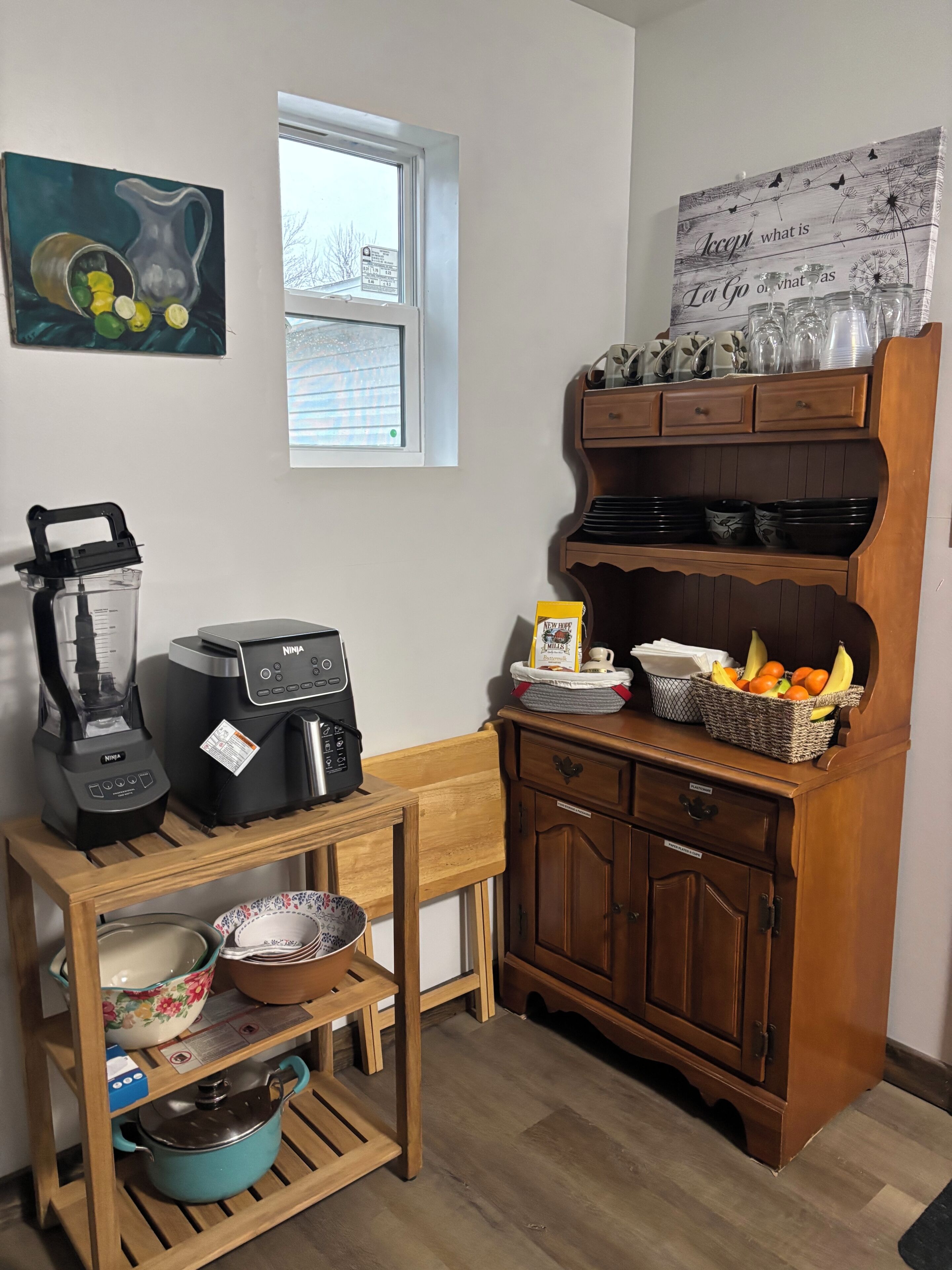 Eine Küche mit Mixer, Kaffeemaschine, Küchenschrank und Fenster.
