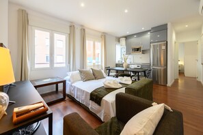 A hotel room with a bed, a desk, a chair, a sofa, a TV, a microwave, and a refrigerator. - M Mal71b Moderno Piso de 1 Dormitorio en Madri (Madrid)