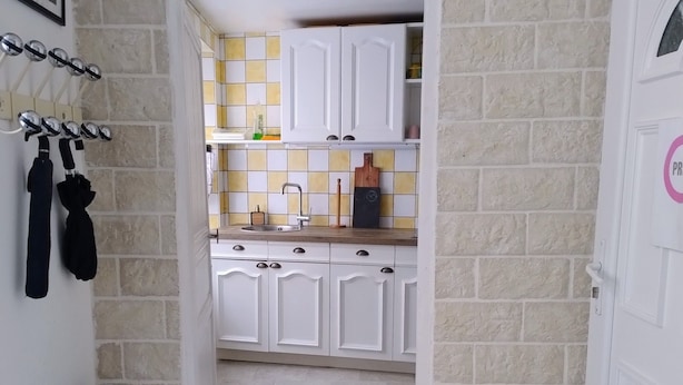 A kitchen with white cabinets, a tiled backsplash, and a wooden countertop. - Family Stay at Gîte Iza – Lormes, Morvan (Lormes)