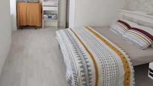 A bedroom with a bed, a wardrobe, a desk, and a hanging light fixture. - Family Stay at Gîte Iza – Lormes, Morvan (Lormes)