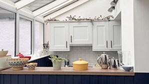A modern kitchen with white cabinets, a wooden countertop, and a skylight. - Cottage 492 - Clifden - sleeps 5 guests  in 3 bedrooms (Clifden)