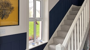 A staircase with white railings and grey carpeted steps leading to a landing with a window. - Cottage 492 - Clifden - sleeps 5 guests  in 3 bedrooms (Clifden)