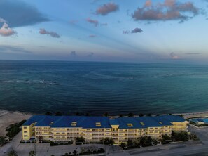 Un hotel de varios pisos con techo azul, situado cerca de una playa y con vista al océano.