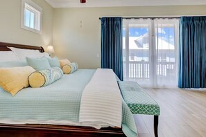 A bedroom with a bed, a bench, and a view of a balcony. - Ocean-View Escape  — Steps to the Beach! (Myrtle Beach)