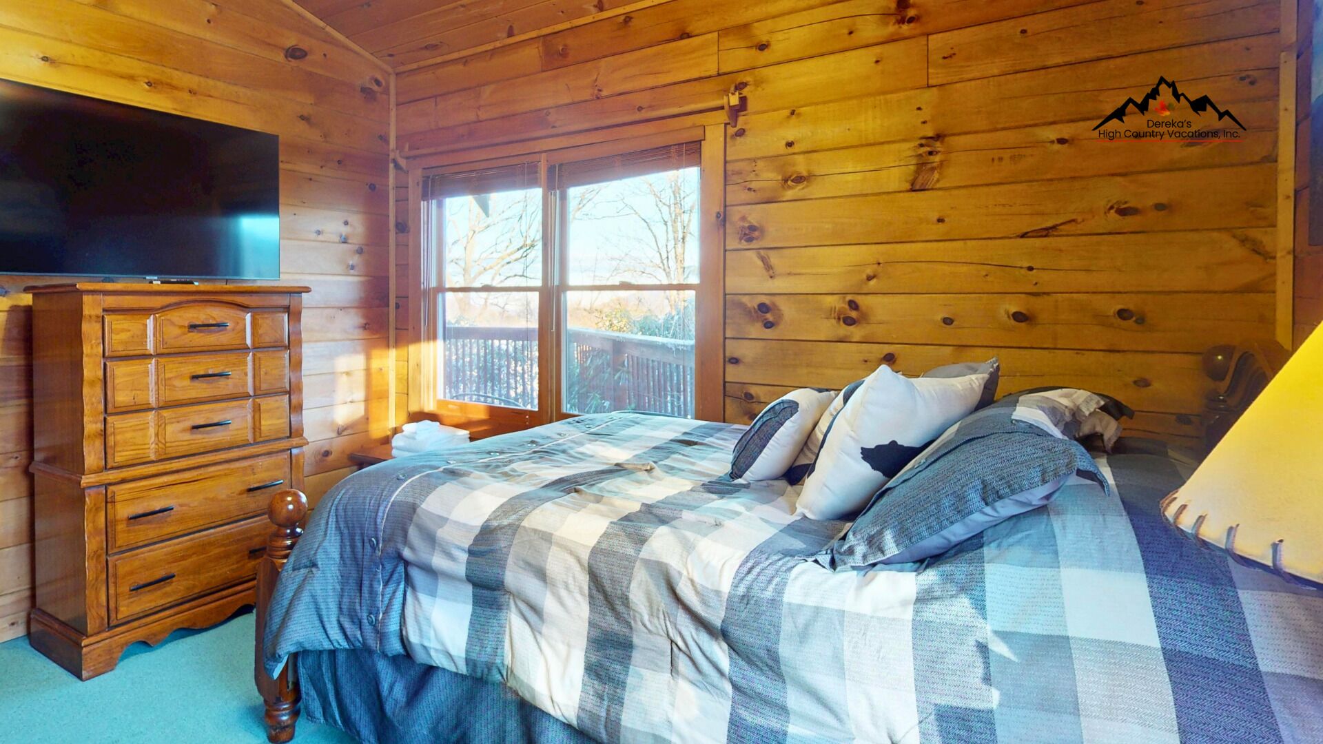 Une chambre dans un chalet en bois, avec un lit, une commode et un téléviseur.