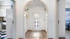 A hallway with a white door, patterned floor tiles, and a checkered floor in the background. - Holiday Home with Shared Pool (Albufeira)