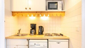 A compact kitchen with a microwave, coffee maker, and a dishwasher. - Mountain hideaway in Risoul (Risoul)