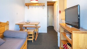 A small, cozy room with a bed, a wooden desk, a television, and a red hanging lamp. - Mountain hideaway in Risoul (Risoul)