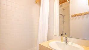 A bathroom with a white sink, mirror, and shower. - Mountain hideaway in Risoul (Risoul)