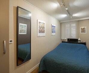 A hotel room with a large bed, a bedside table with a lamp, a mirror, and three framed pictures on the wall. - Strasbourg Cathedral, Optional services not included in the price (Strasbourg)