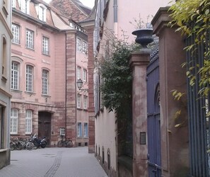 A narrow street with historic buildings, a blue gate, and bicycles parked on the side. - Strasbourg Cathedral, optional services not included in the price (Strasbourg)