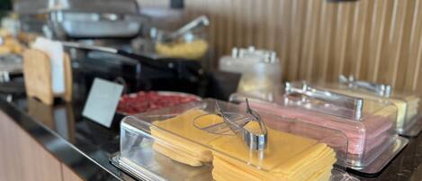 A buffet with various food items in clear containers, including what appears to be cheese and meat.