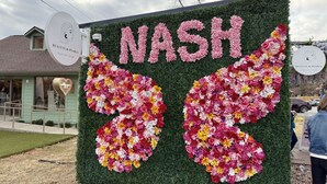 Une composition florale avec le mot « NASH » au centre, entourée d’une haie.