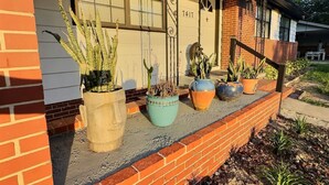 A house with a brick exterior, a front porch with potted plants, and a garage door with the number 7417. - Wonder Way: Sleeps 8! 4Bd/2Bth/Gym~Near NAS Jax~ (Jacksonville)