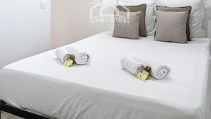 Una habitación de hotel con cama, almohadas y toallas.