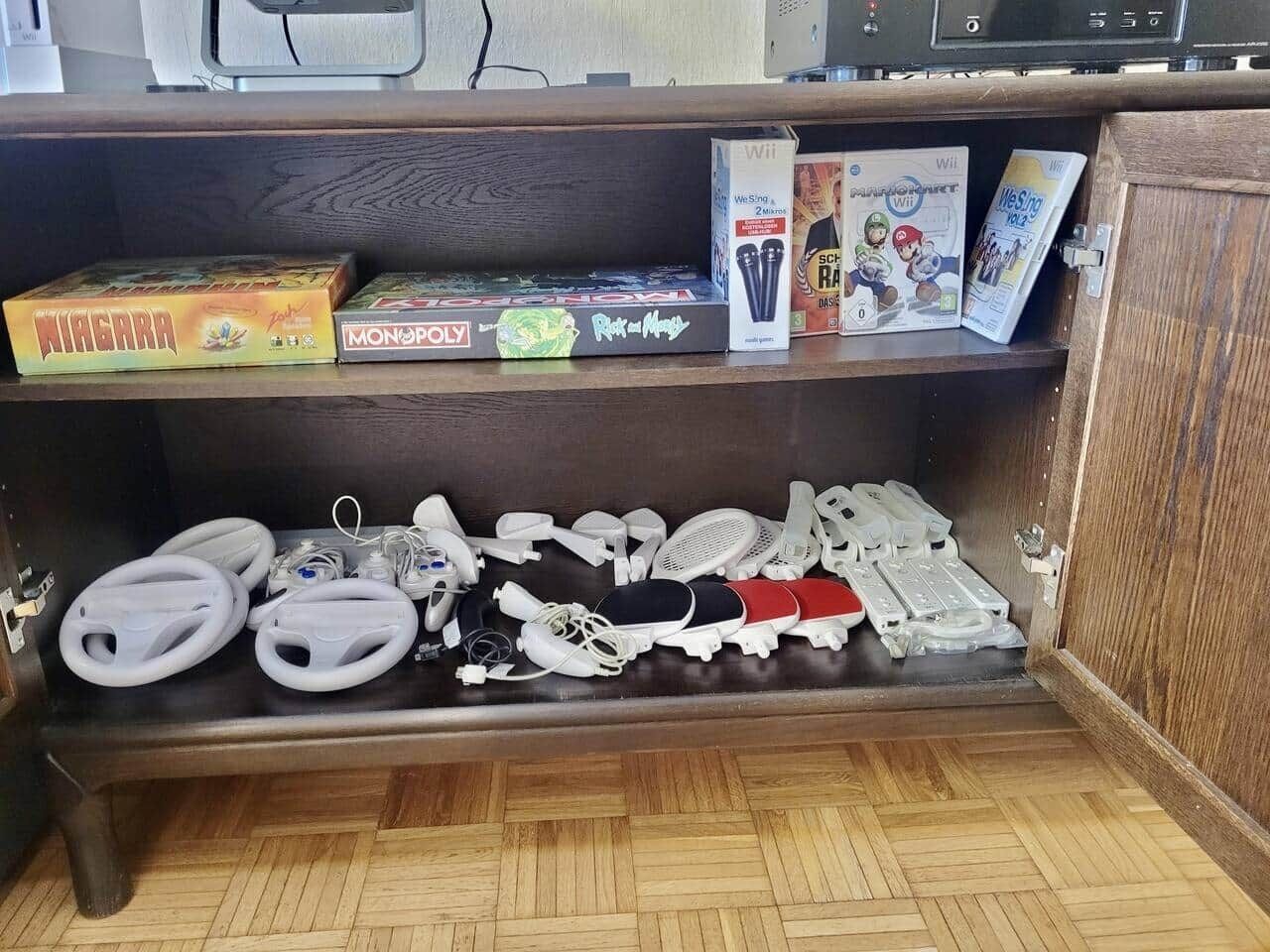 Un mueble de madera con varios dispositivos electrónicos y consolas de videojuegos.