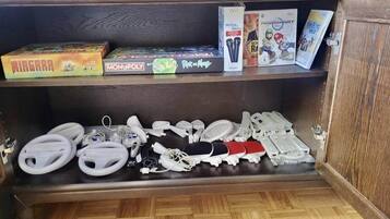 Un mueble de madera con varios dispositivos electrónicos y consolas de videojuegos.