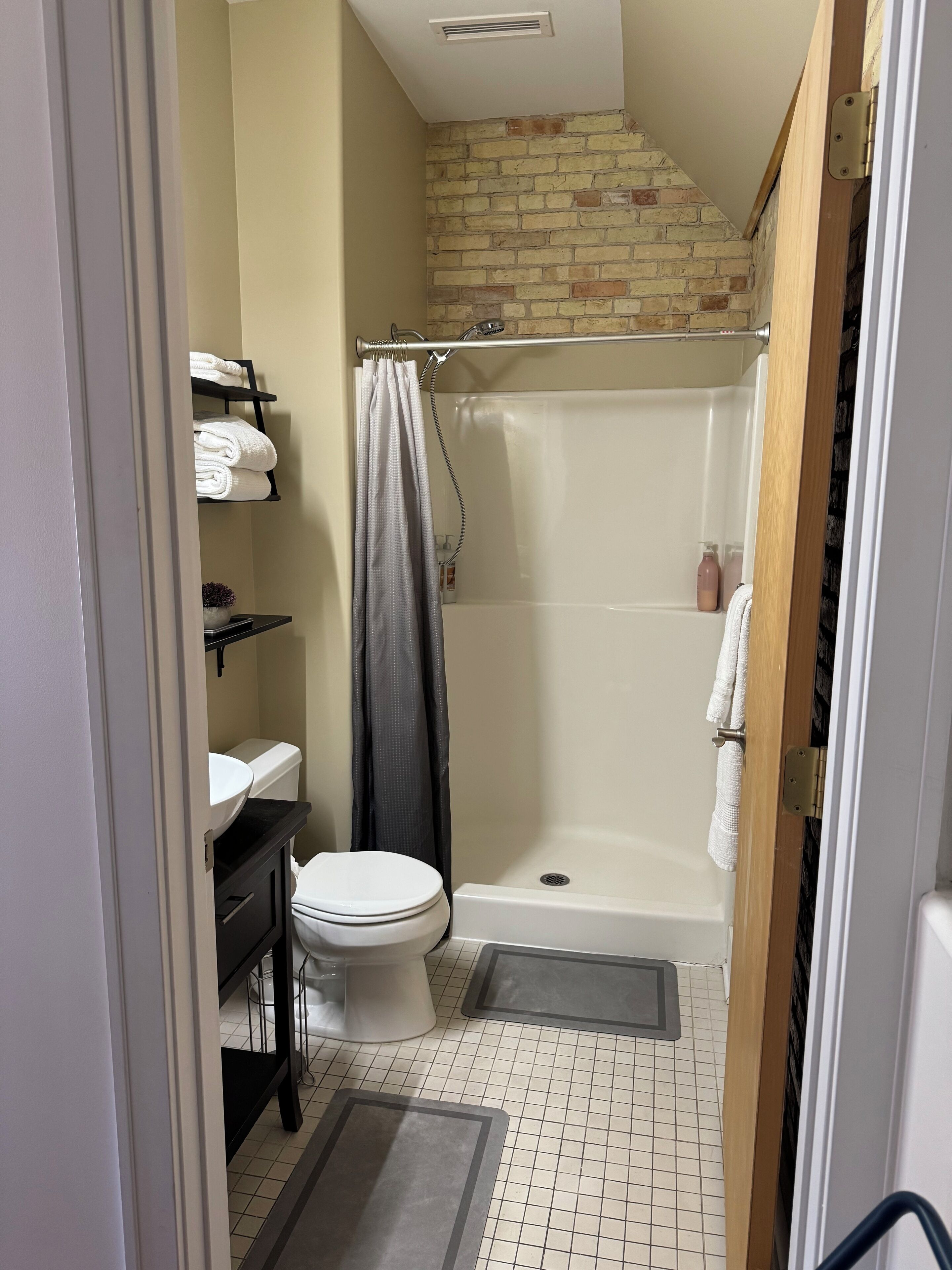 Une petite salle de bain avec des toilettes, un lavabo et une douche.