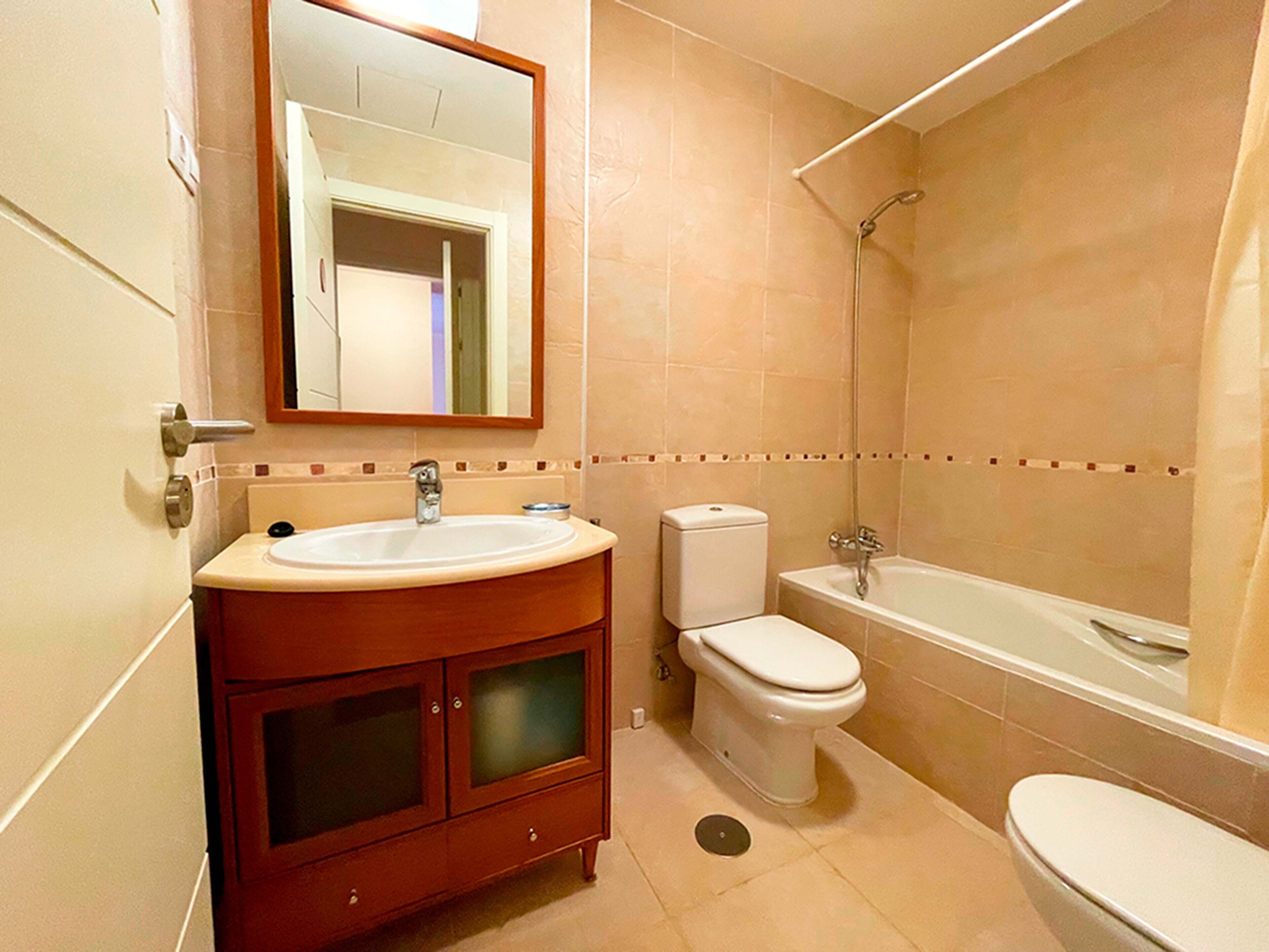 A bathroom with a sink, toilet, and bathtub.