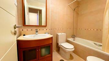 A bathroom with a sink, toilet, and bathtub.
