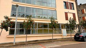 A two-story building with large windows and a flat roof. - Apartamentos Las Margas Sabiñanigo 3000 (Sabiñánigo)