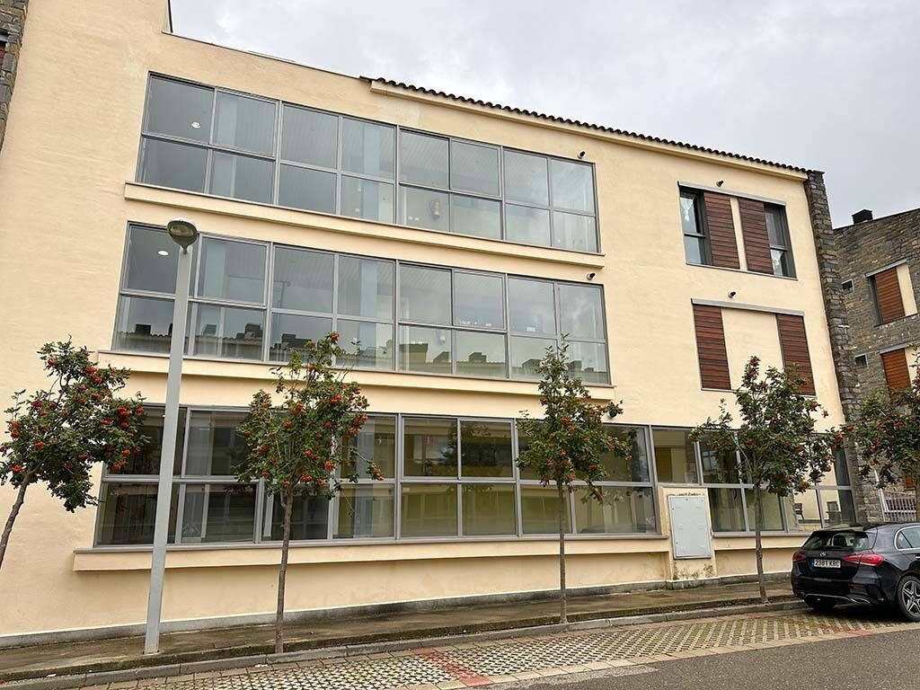 A two-story building with large windows and a flat roof.