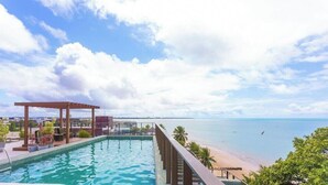 Ein Pool auf dem Dach mit Blick auf Strand und Meer.