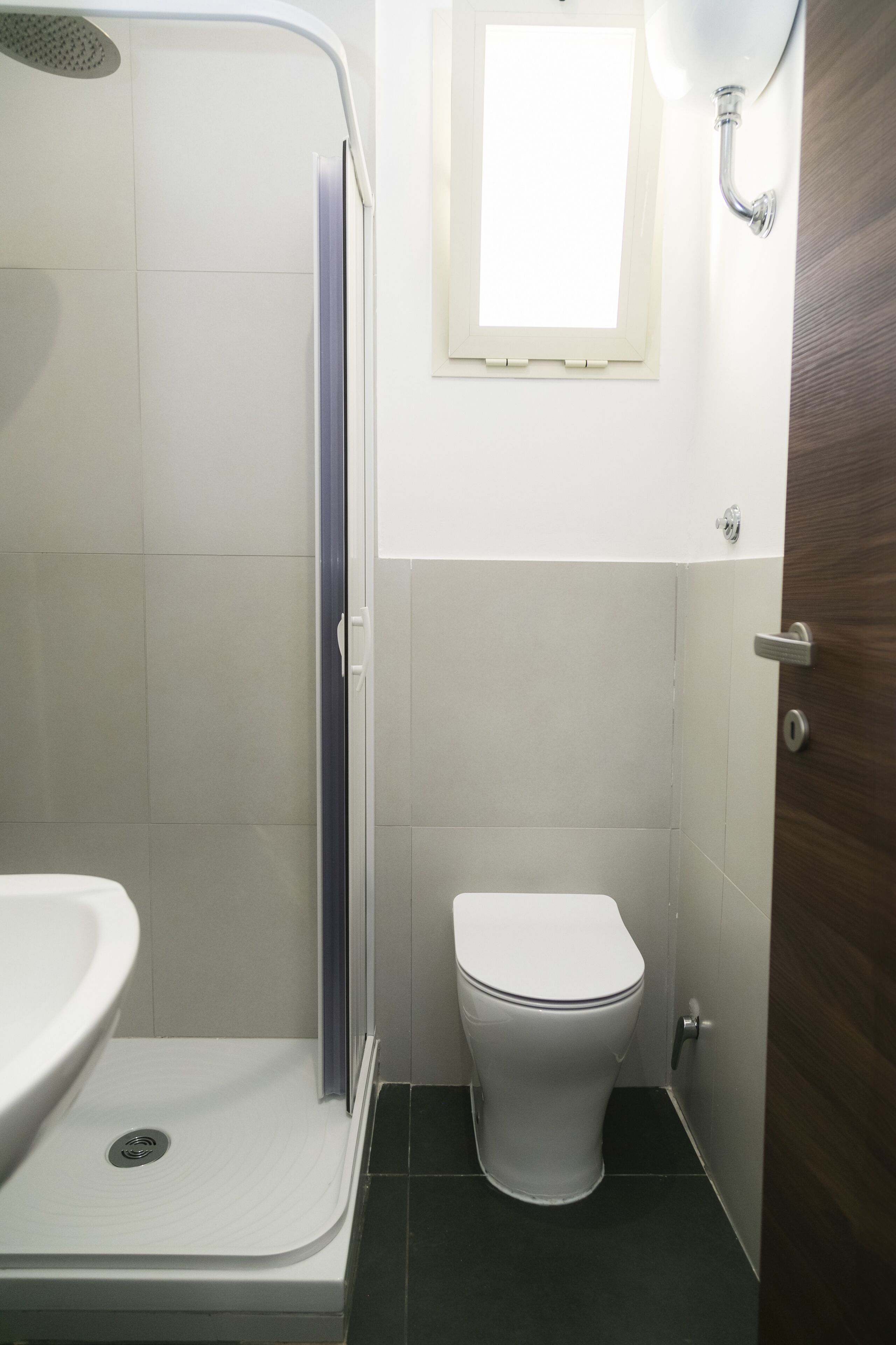 Une salle de bain avec douche, toilettes et lavabo.