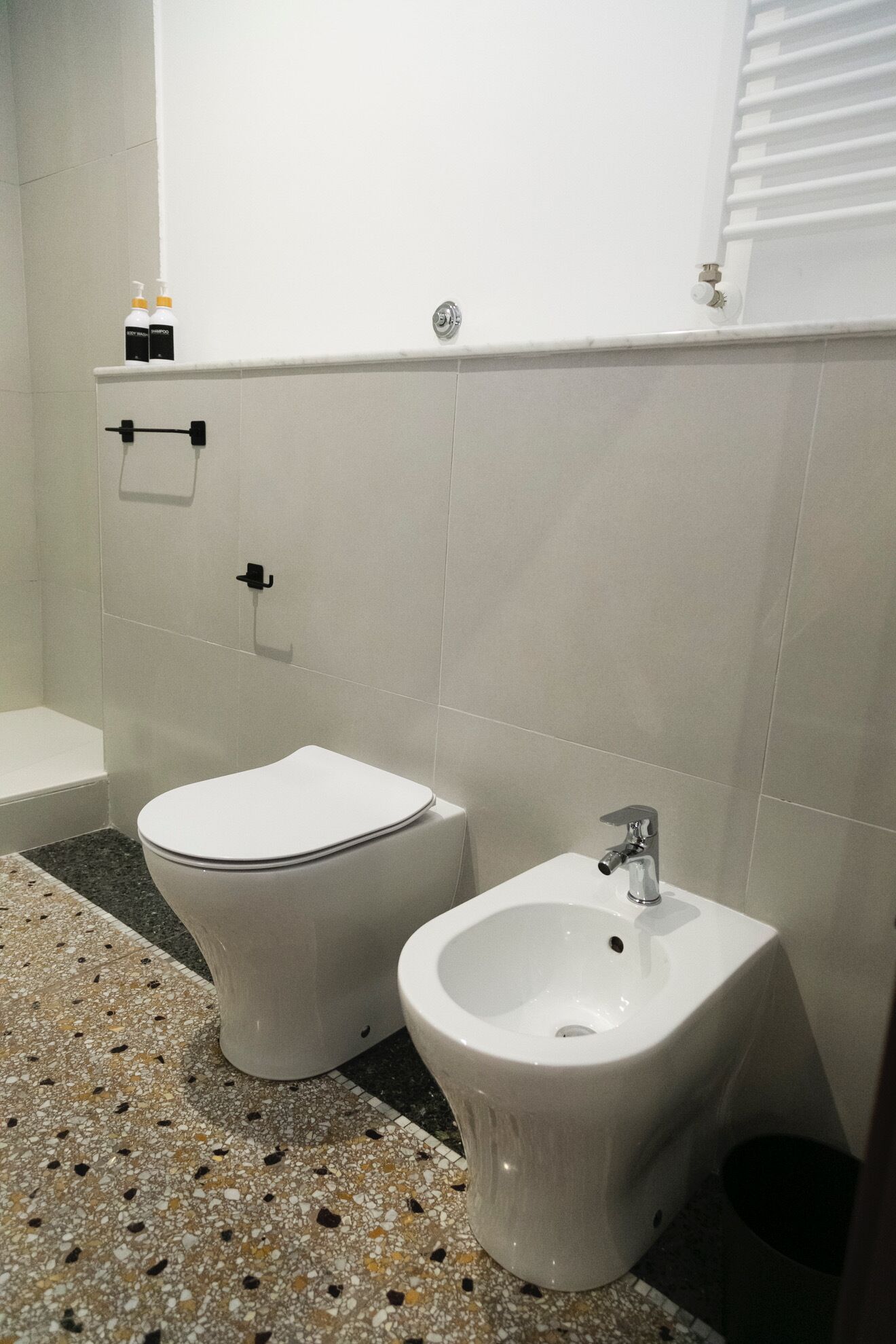 A bathroom with a toilet, bidet, and a sink.