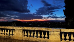 A balcony with stone balustrades and a cityscape view at dusk. - la terrazza (Tivoli)