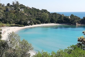 A coastal landscape with a sandy beach, clear turquoise waters, and a forested hillside with buildings. - Charming Seaside property Porto Vecchio region,Corsica (Solaro)