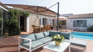 A poolside area with a sofa, chairs, and a table. - Artist's property/Pool 10X5/garden orchard (Rivedoux-Plage)