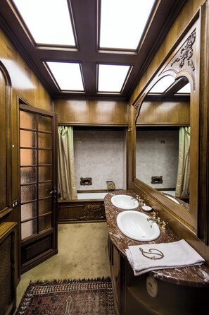 A traditional bathroom with a skylight, two sinks, and a large mirror. - Villa Dom (Piacenza)