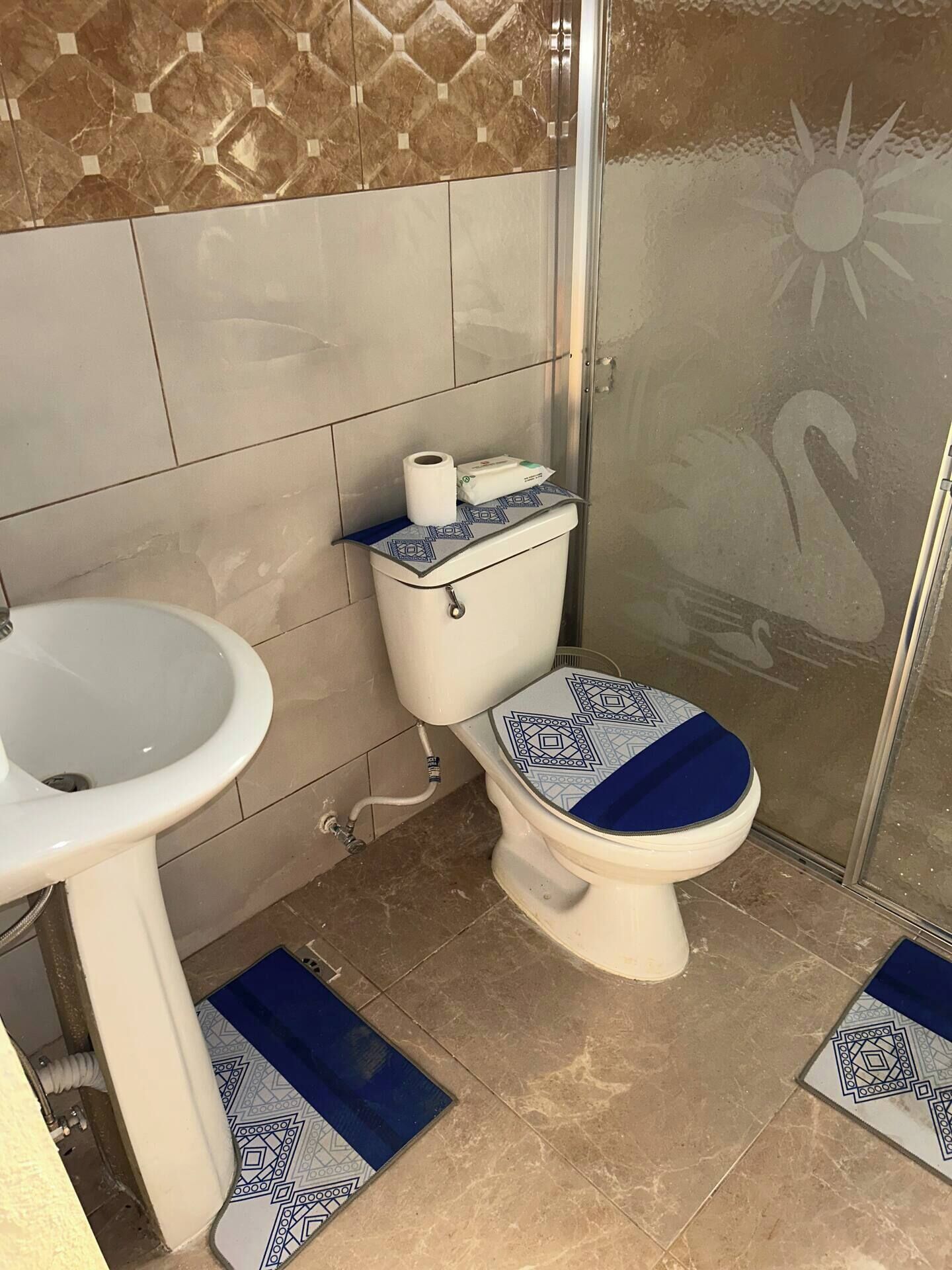 A bathroom with a toilet, sink, and shower area.