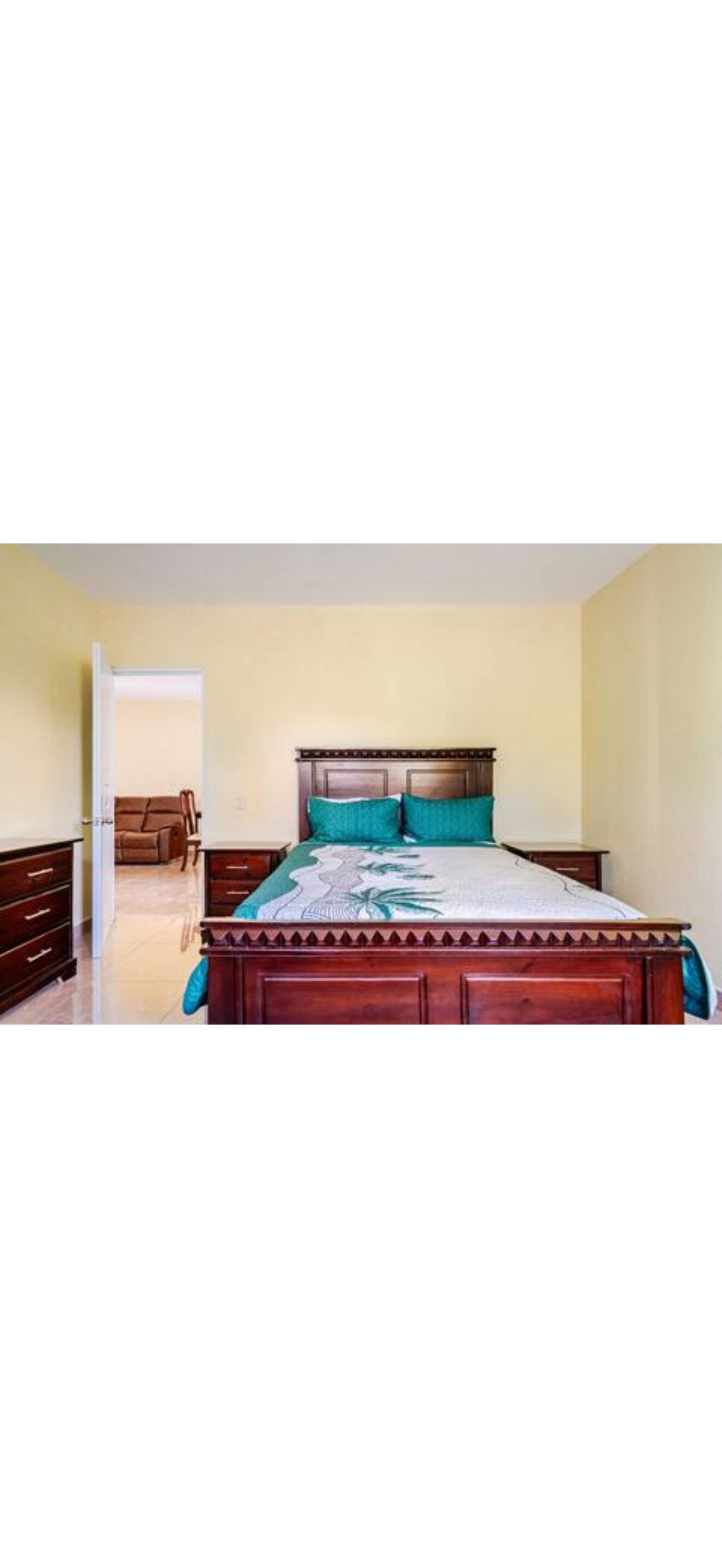 A bedroom with a wooden bed, a nightstand, a dresser, and a chair.