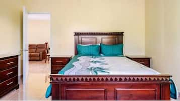 A bedroom with a wooden bed, a nightstand, a dresser, and a chair.