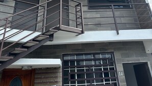 Un edificio moderno con una escalera que conduce a un balcón, un ventanal grande y una puerta con el número 14.