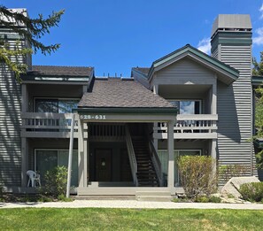 A two-story building with a covered front porch, a staircase, and a visible phone number. - Snowcreek Resort Vacation Rental 629 (Mammoth Lakes)