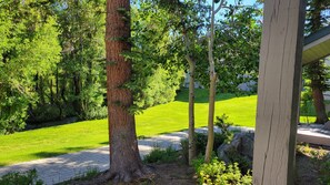 A well-maintained garden with a paved walkway, a variety of trees, and a grassy lawn. - Snowcreek Resort Vacation Rental 629 (Mammoth Lakes)