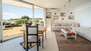 Una sala moderna con comedor, ventanas amplias y vistas al exterior.