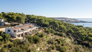 Propiedad costera con varias villas, abundante vegetación y vista al mar.