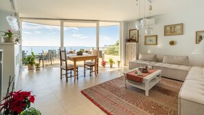 Un salón amplio con un gran ventanal, un comedor y un sofá.