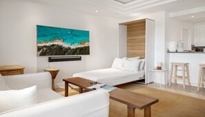 Ein modernes Hotelzimmer mit Bett, einer Couch, einem Couchtisch und einem Gemälde an der Wand.