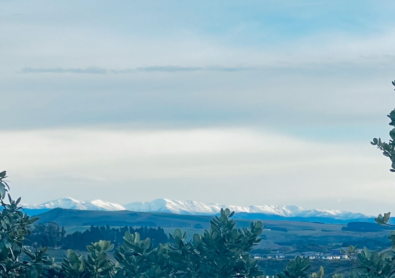 Un paisaje montañoso con picos nevados y un cielo despejado.