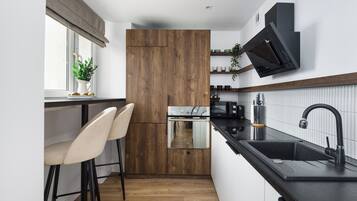 Apartamento Deluxe, vistas a la ciudad | Cocina privada | Frigorífico grande, microondas, horno y placa de cocina