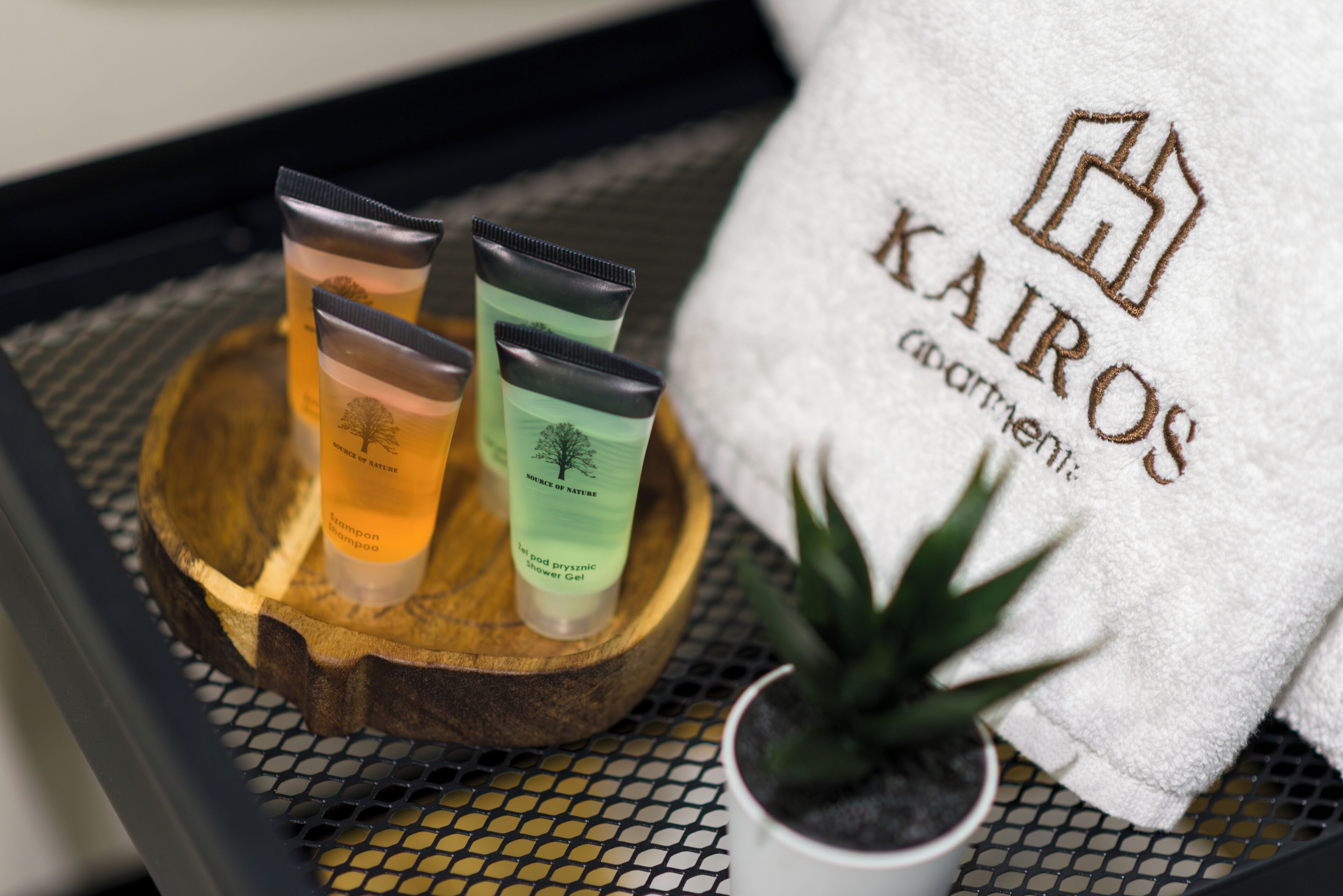 A tray with three toiletry bottles and a towel with the text "KAIROG".