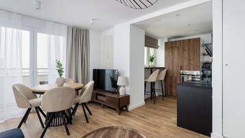 Departamento Deluxe, vista a la ciudad | Área de sala de estar | Smart TV de 50 pulgadas con canales por cable y oficina