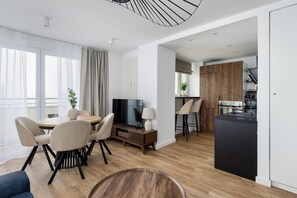 Deluxe-Apartment, Stadtblick | Wohnbereich | 50-Zoll-Smart-TV mit Kabelempfang, Arbeitsbereiche