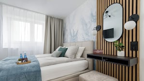Un dormitorio moderno con cama, mesita de noche y televisión montada en la pared.