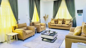 A modern living room with two sofas, a coffee table, and a small side table. - Urban Ts (Abuja)